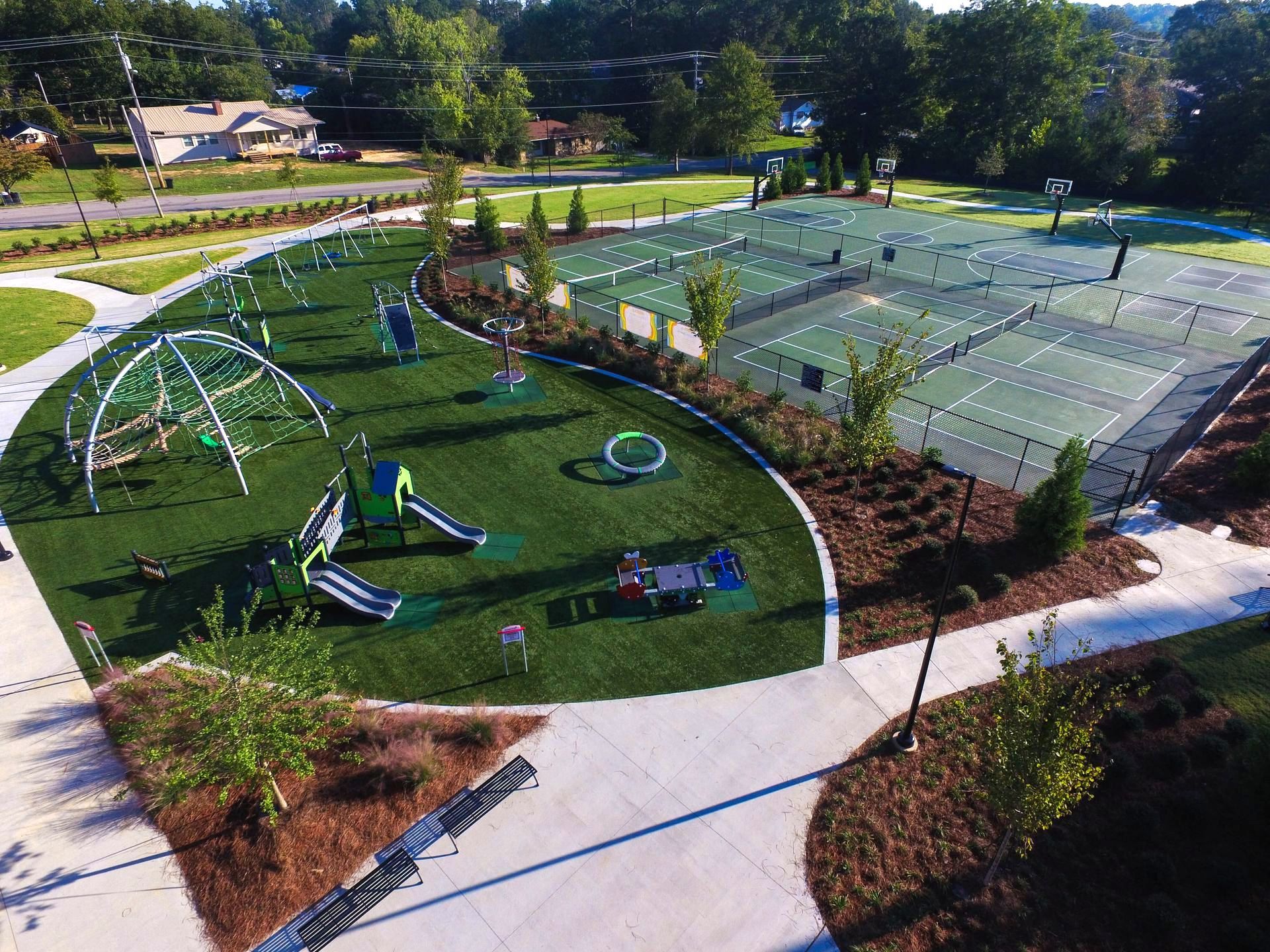An aerial view of a park with tennis courts and a playground