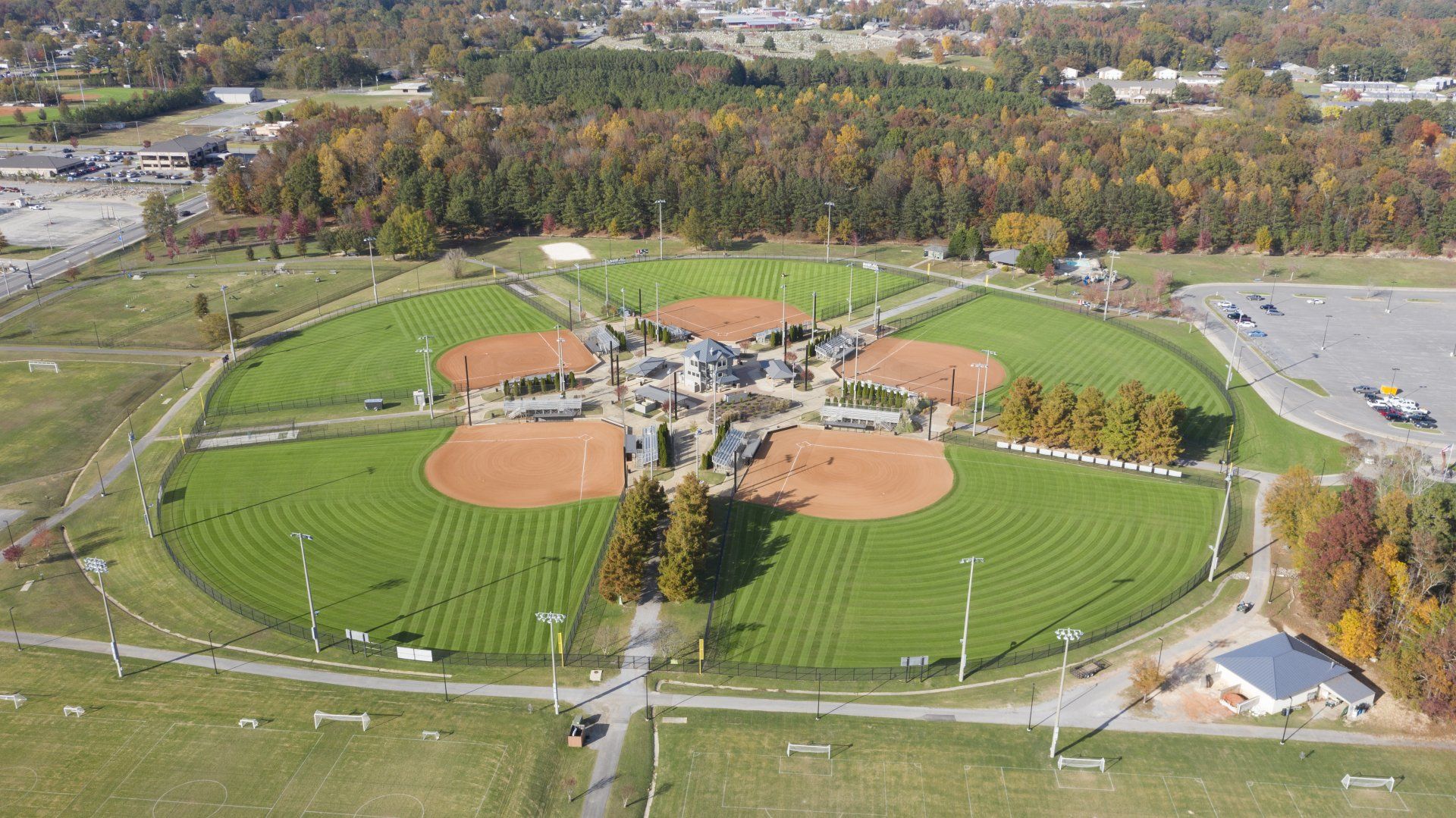 An aerial view of a baseball field with trees in the background