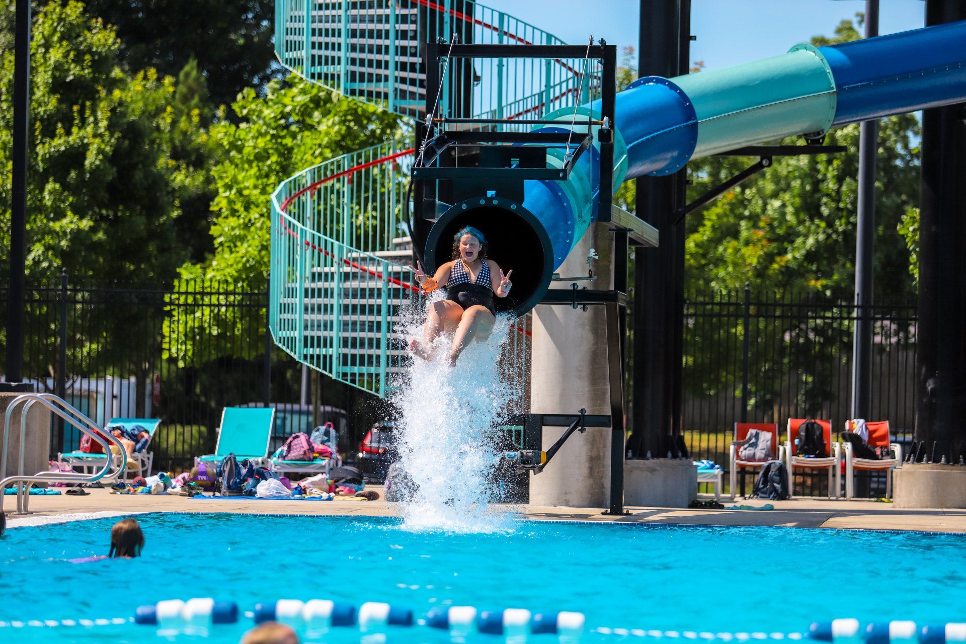 A person is sliding down a water slide into a pool
