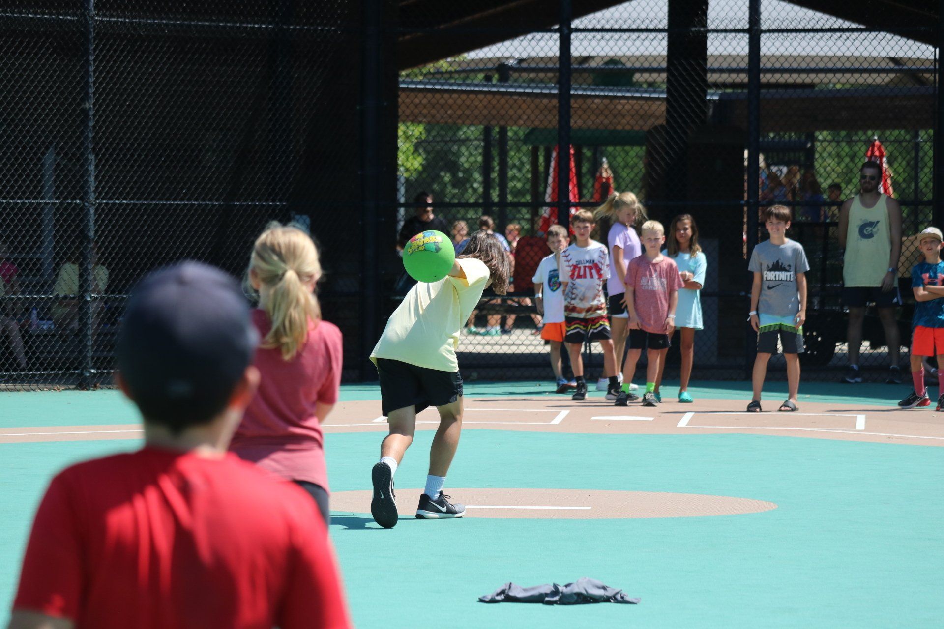 A group of children are playing a game of frisbee on a court.