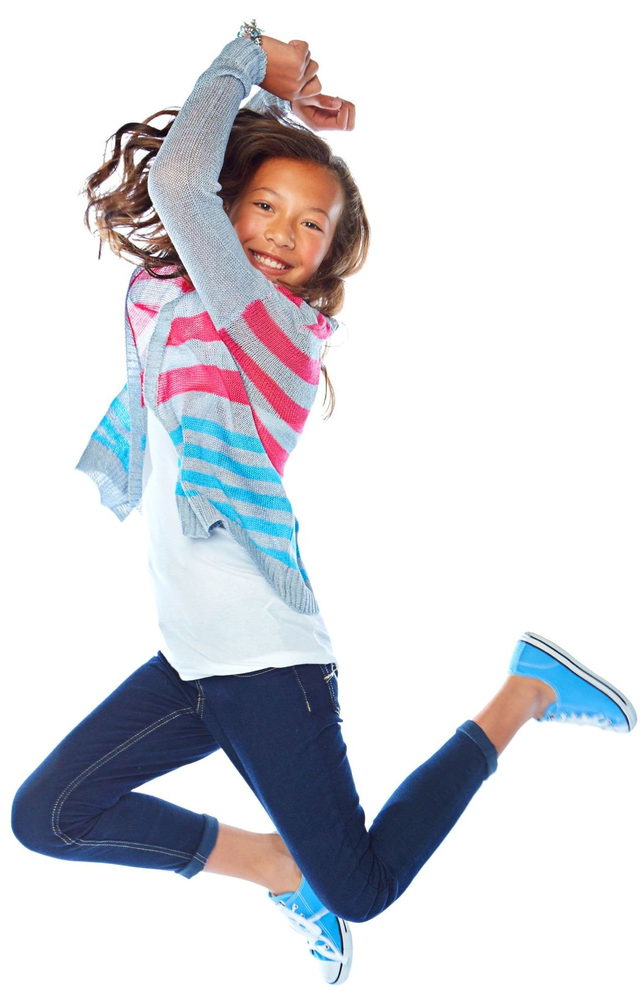 A young girl is jumping in the air with her arms in the air.