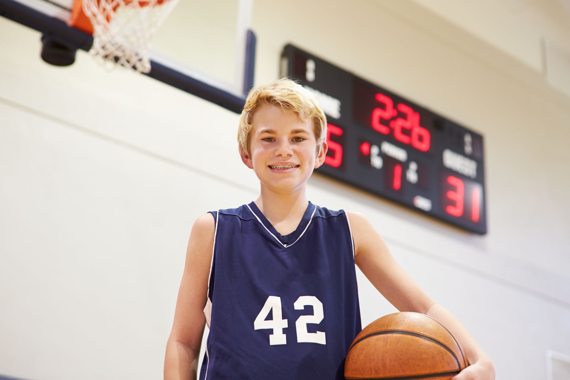 A young boy wearing a basketball jersey with the number 42 on it