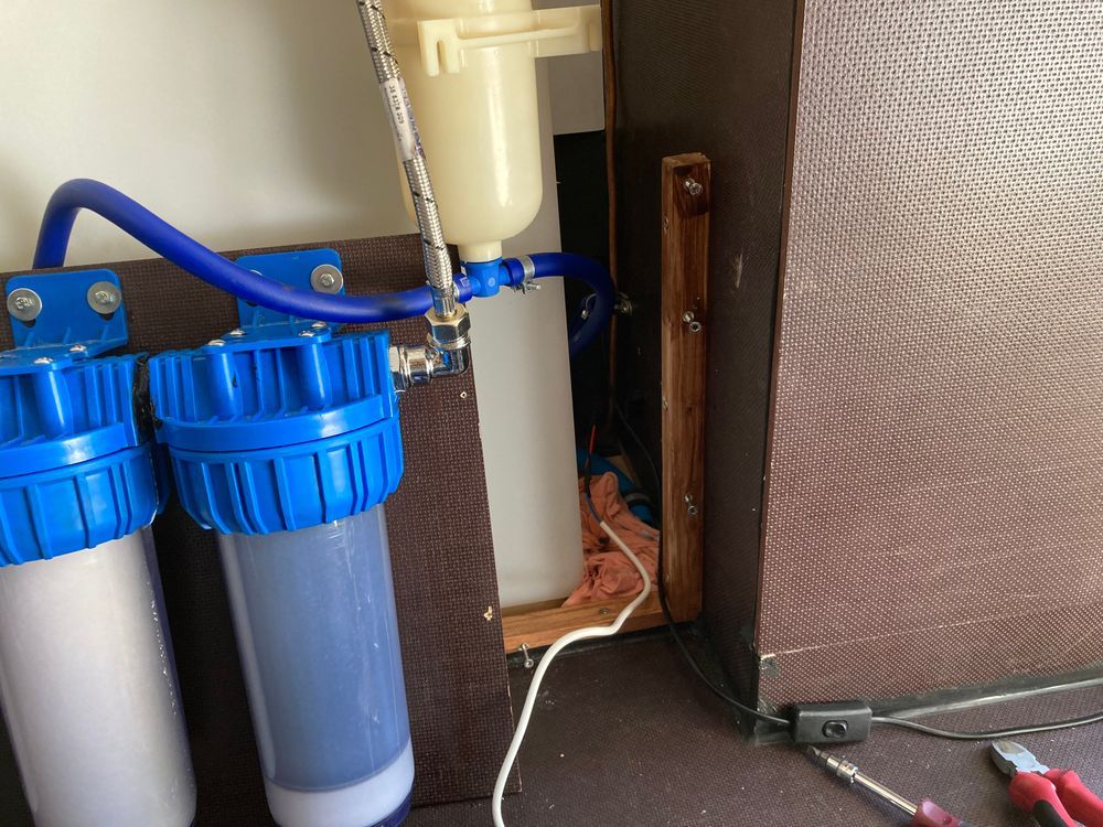 a pair of pliers sits next to a water filter
