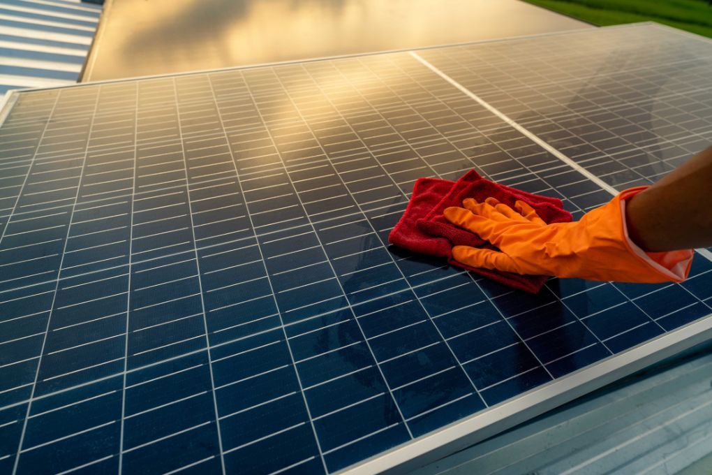Roofers Kilmarnock cleaning a solar panel by hand