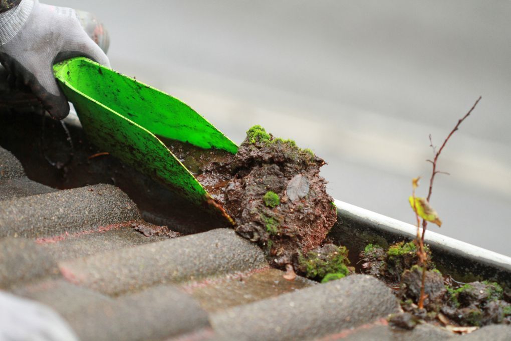 Roofers Kilmarnock hand gutter cleaning with a trowel before cleaning