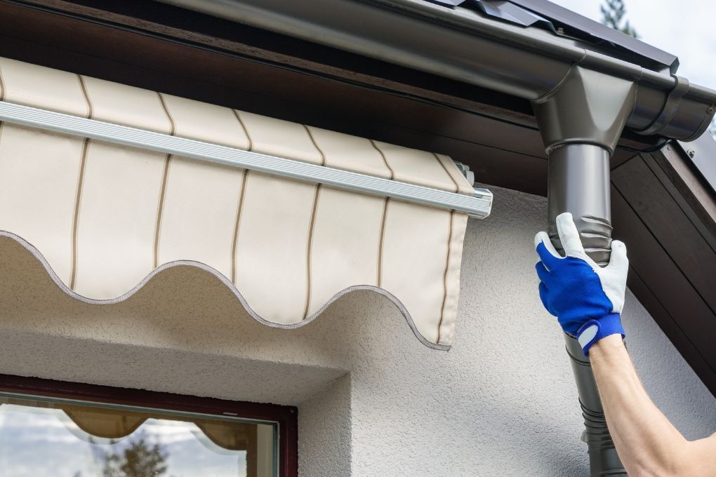 Roofers Kilmarnock fitting a new down pipe to the guttering