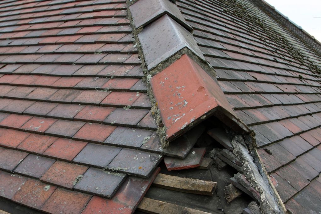 Roofers Kilmarnock about to repair ridge roof tiles at corner section of roof