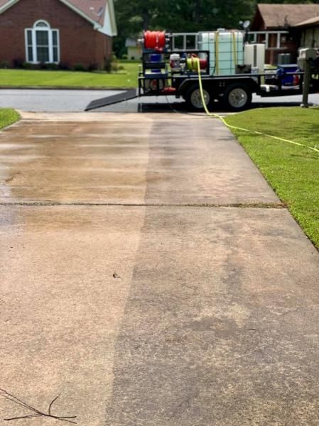 Fire truck parked at the top of a wet driveway in a suburban neighborhood.