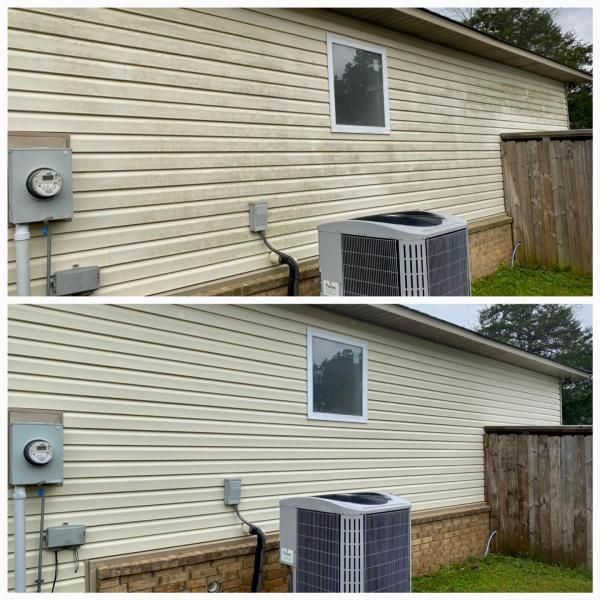Beige house siding with window, utility meters, and outdoor AC unit beside a wooden fence.