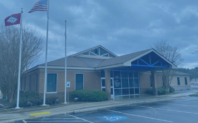 Brick civic building with flags flying outside on an overcast day