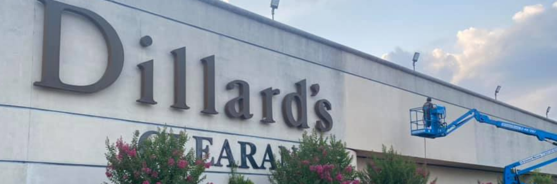Dillard’s store sign on a building exterior with white facade and blue trim
