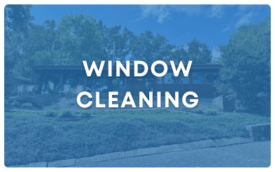 Blue-tinted outdoor sign reading “WINDOW CLEANING” over a suburban house and lawn