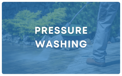 Pressure washing text over a blue-tinted image of a worker cleaning a walkway outdoors