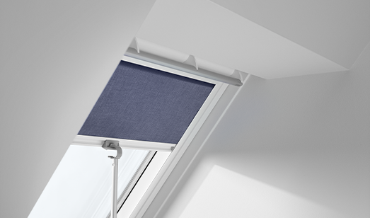 Open skylight with blue blind and a small lamp below