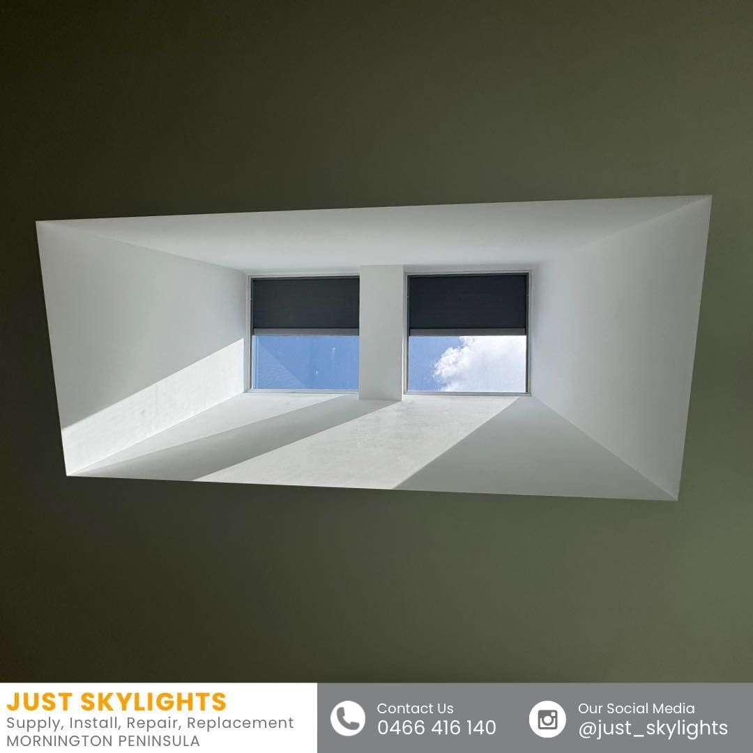 White ceiling skylight with two narrow windows showing blue sky and clouds