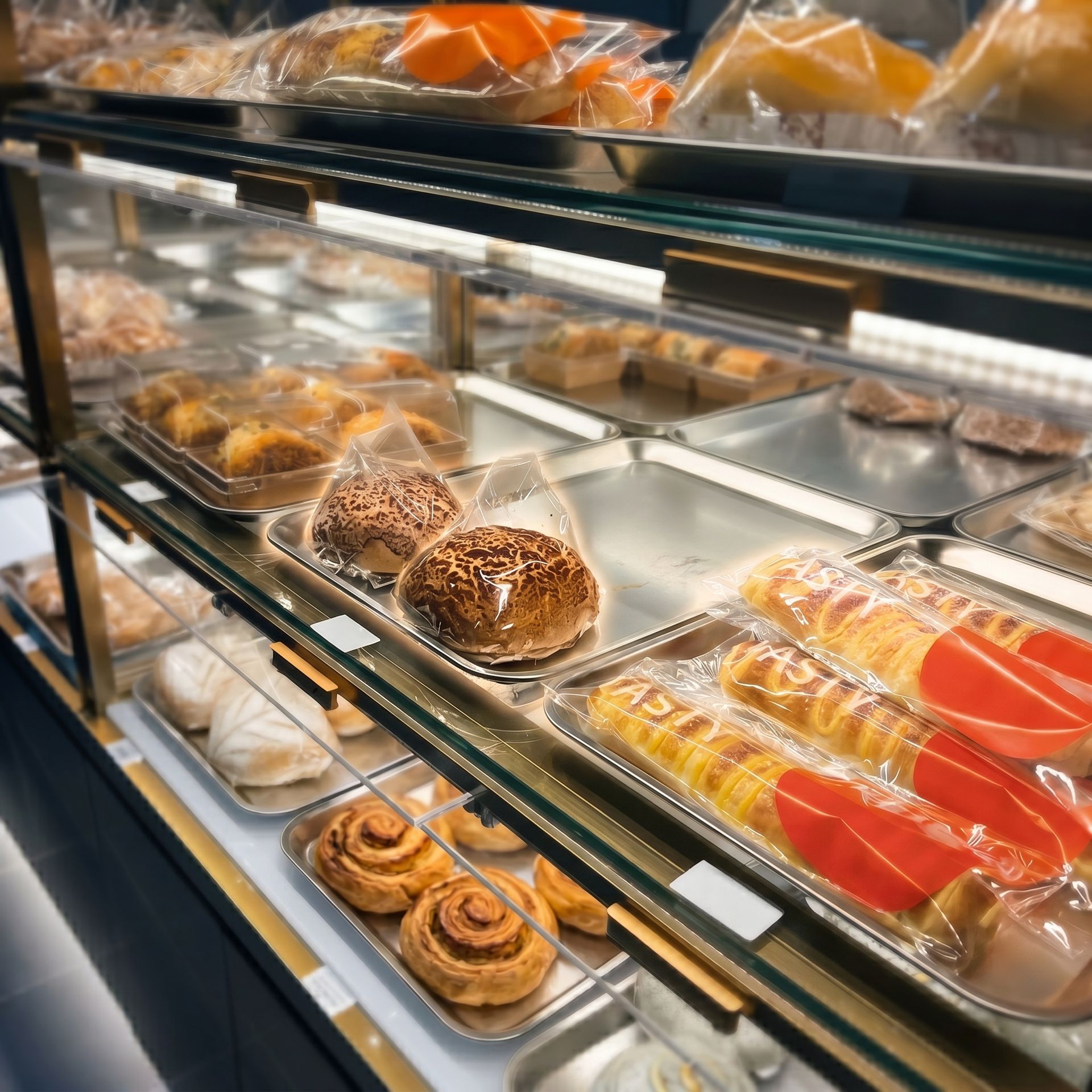 Bakery display case with assorted pastries and cakes on trays and shelves