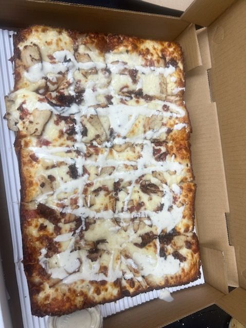 A pizza with a lot of toppings is in a box