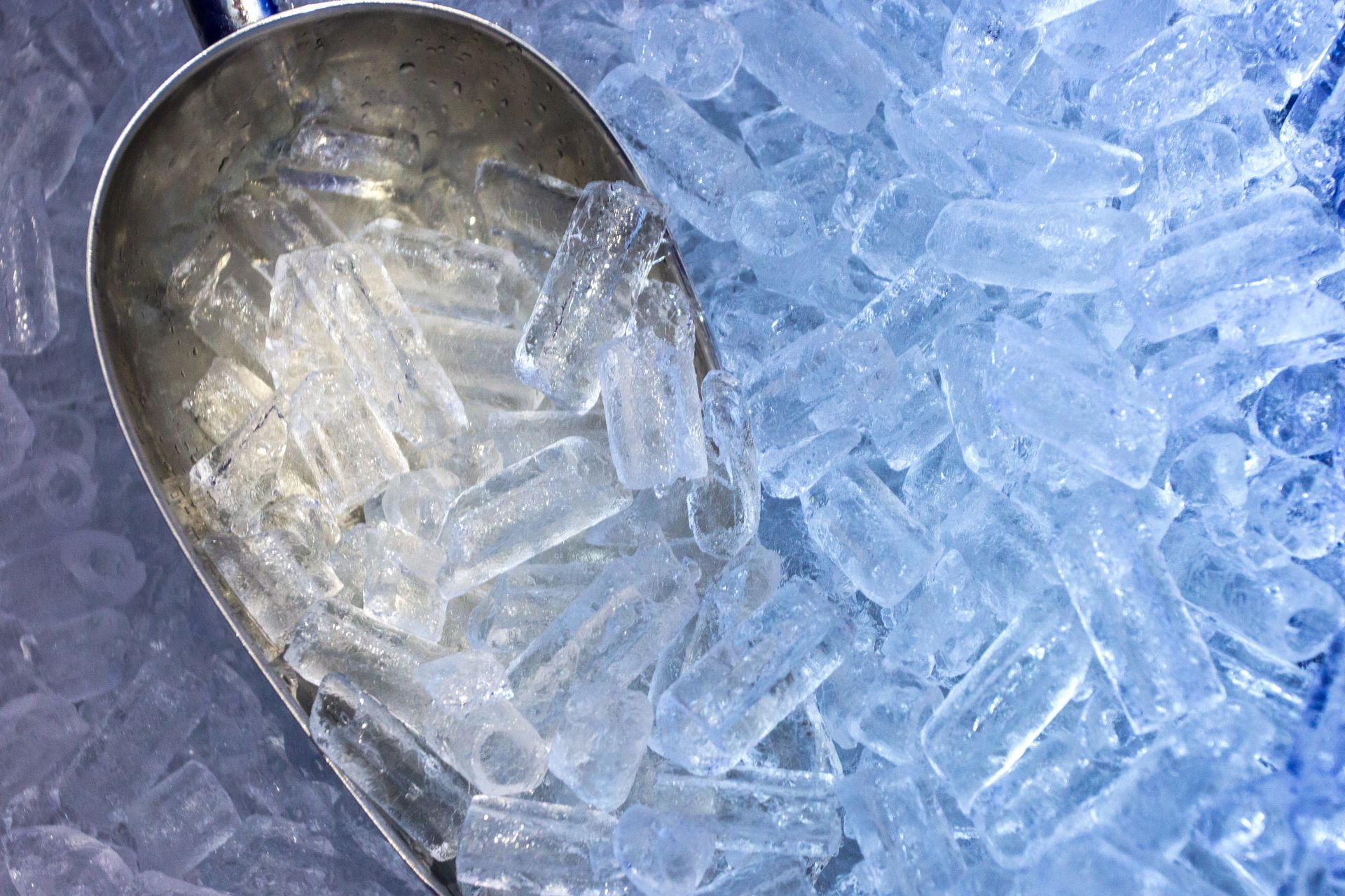 Metal scoop with nugget ice pellets from a commercial ice maker.