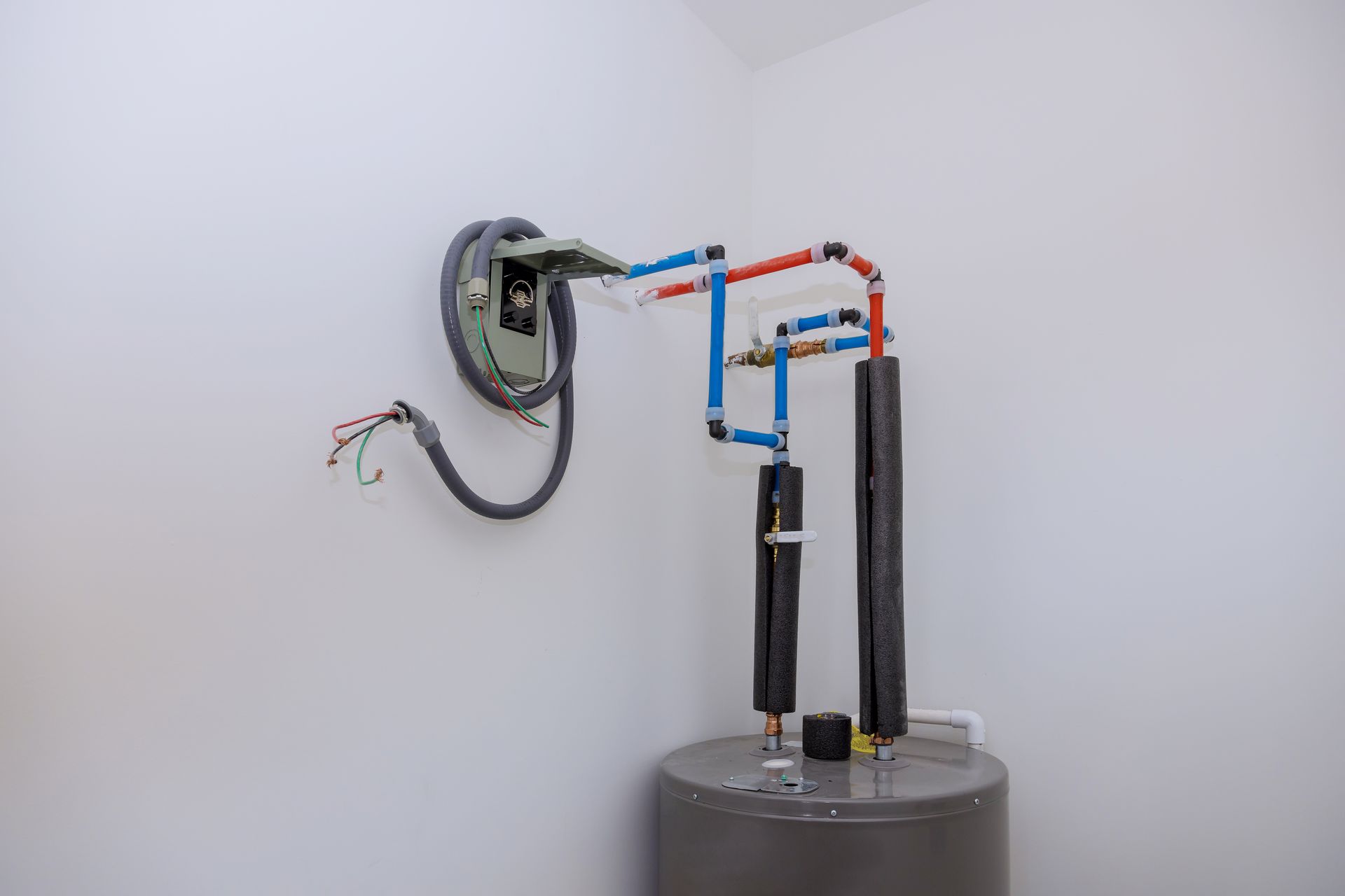 Small robot arm with blue and red tubing mounted on a gray base against a white wall.