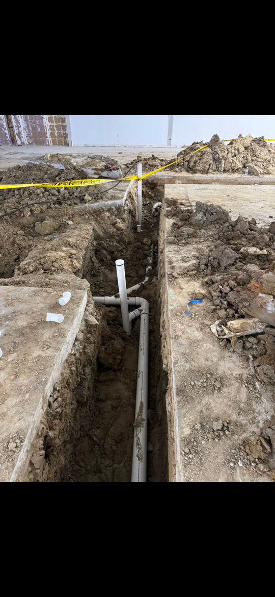 Black industrial pipe with a bolted valve and flange mounted against a concrete wall. Black industrial pipe with a bolted valve and flange mounted against a concrete wall.