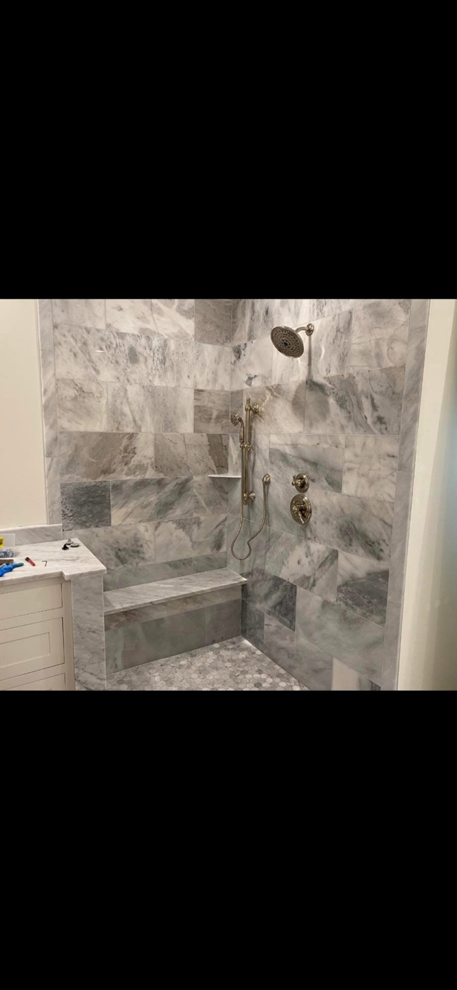 Person working under a sink with exposed plumbing and a white cabinet interior Person working under a sink with exposed plumbing and a white cabinet interior
