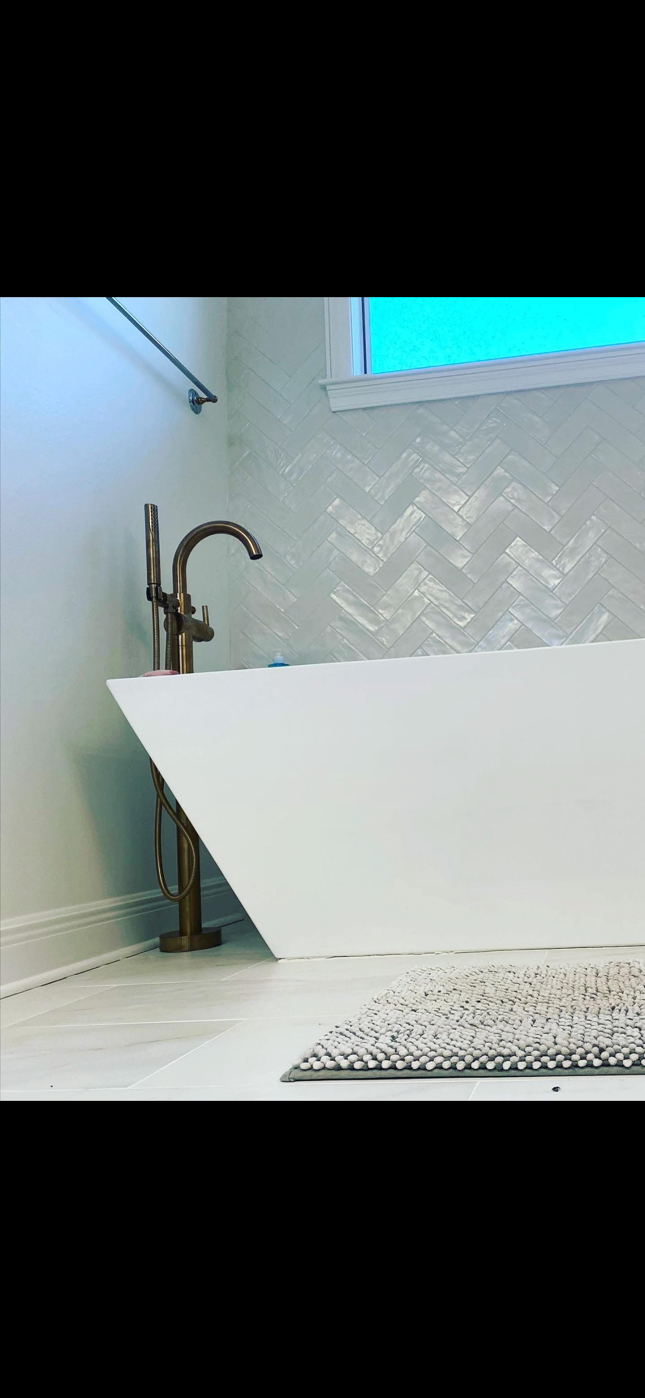 Chrome plumbing fittings and pipes on a white table with a person in blue in the background Chrome plumbing fittings and pipes on a white table with a person in blue in the background
