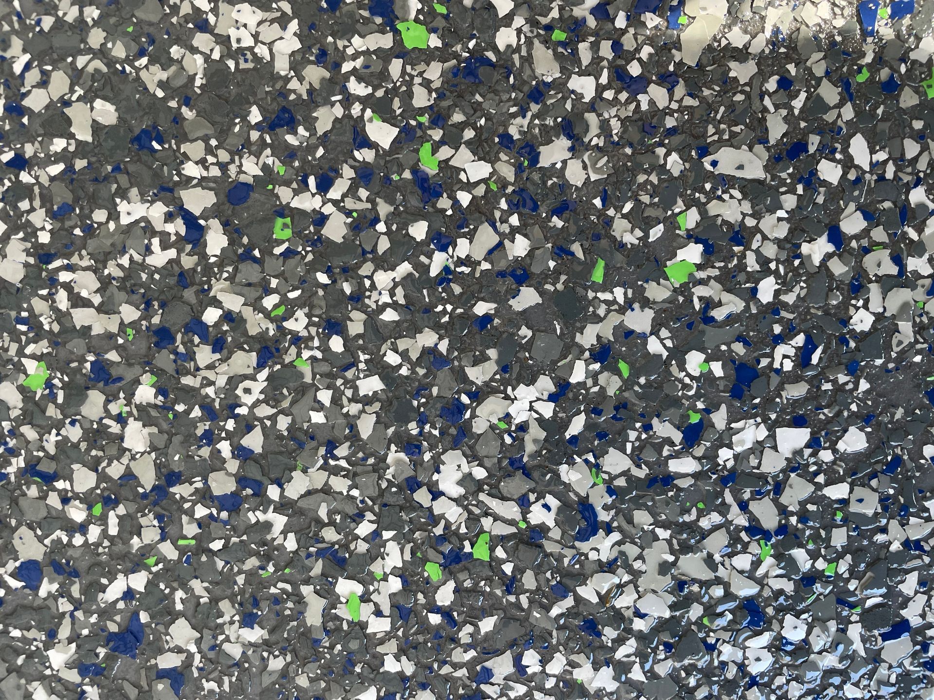 Close-up of speckled gray, white, blue, and green gravel or terrazzo surface