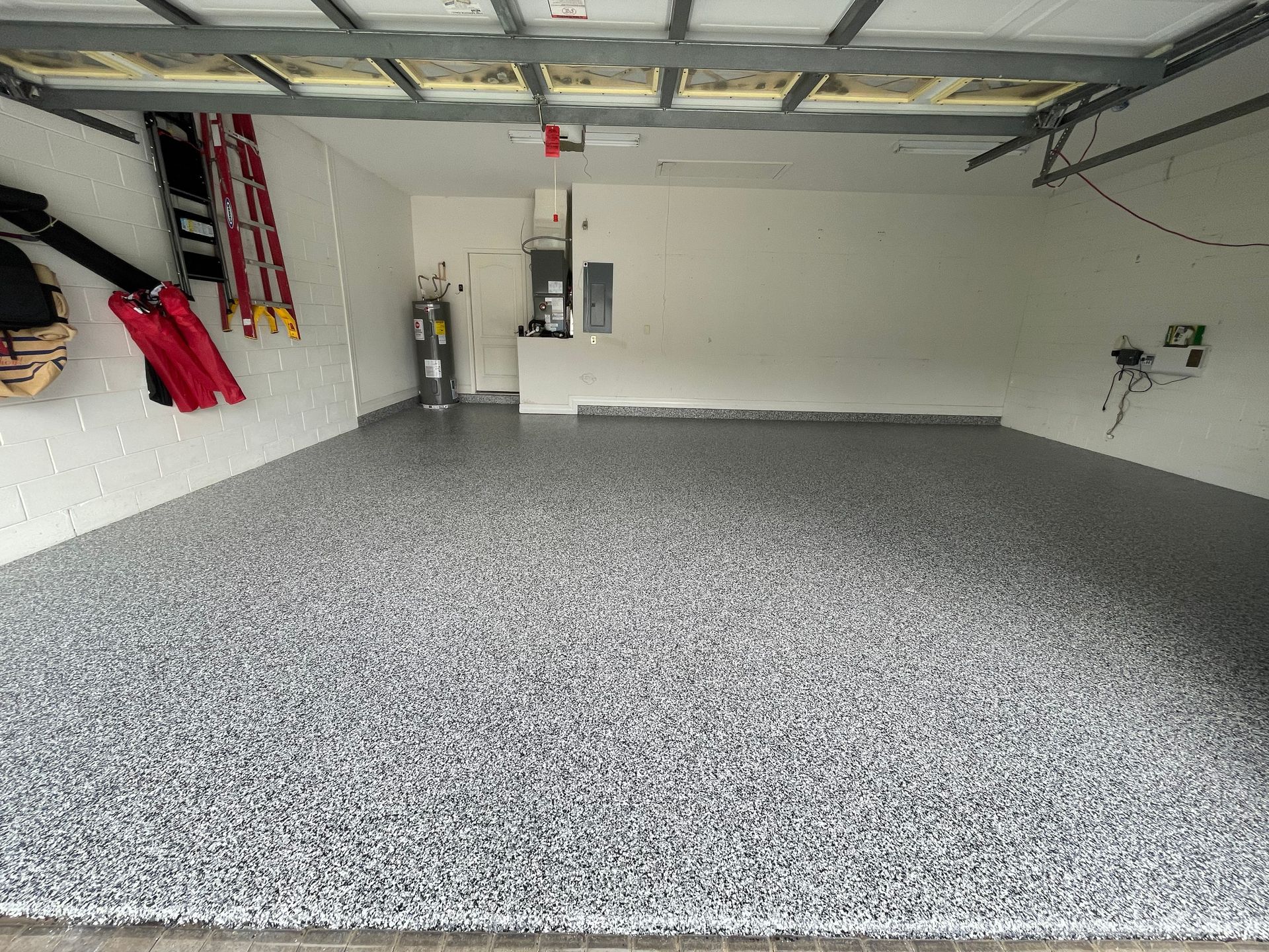 Spacious garage with speckled gray epoxy floor and open overhead door tracks