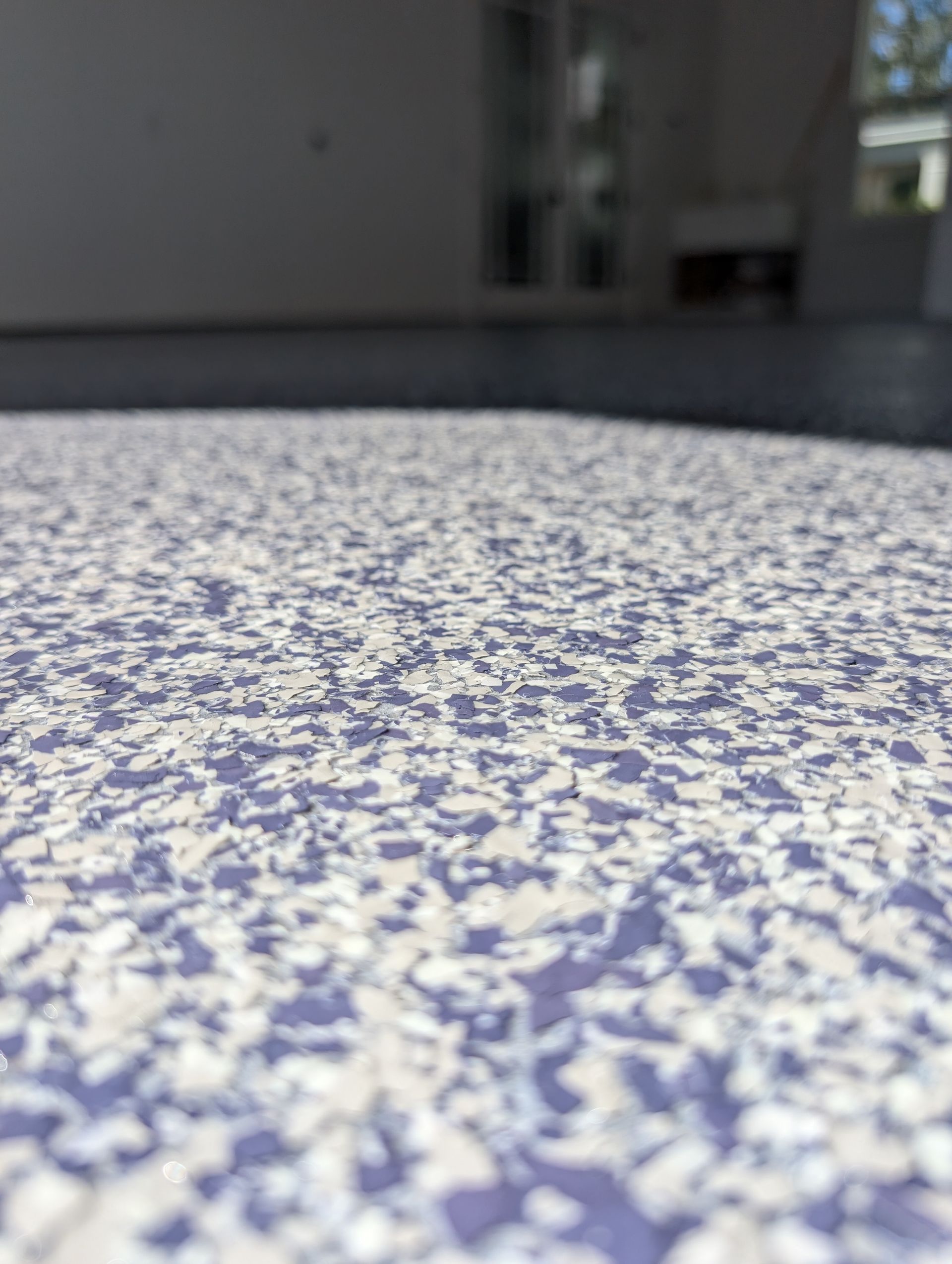 Close-up of a speckled blue-and-white textured surface with a blurred indoor background