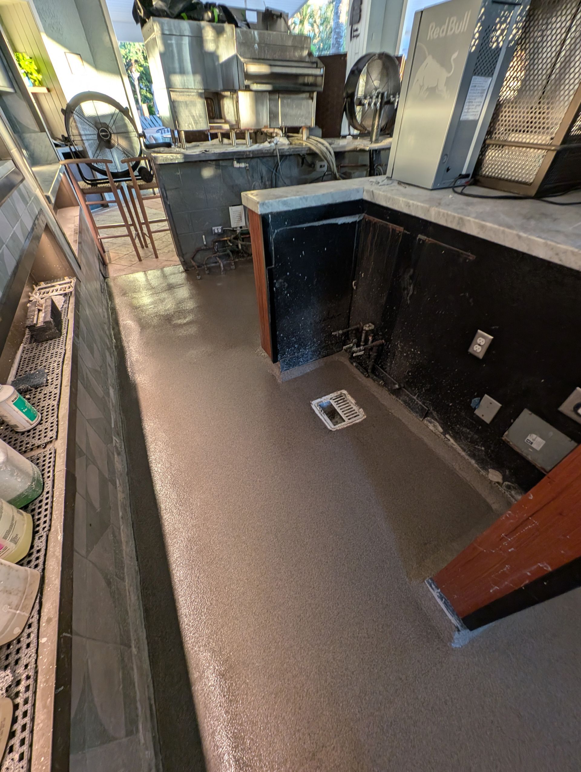 Restaurant interior with a small sunken area, dark counters, and a tiled floor.
