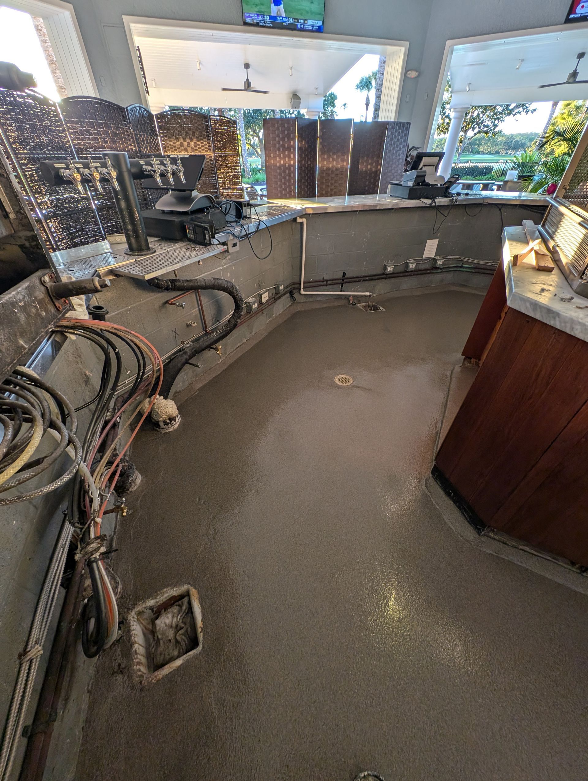 Curved bar counter with equipment, cables, and a sink in a restaurant or café kitchen area