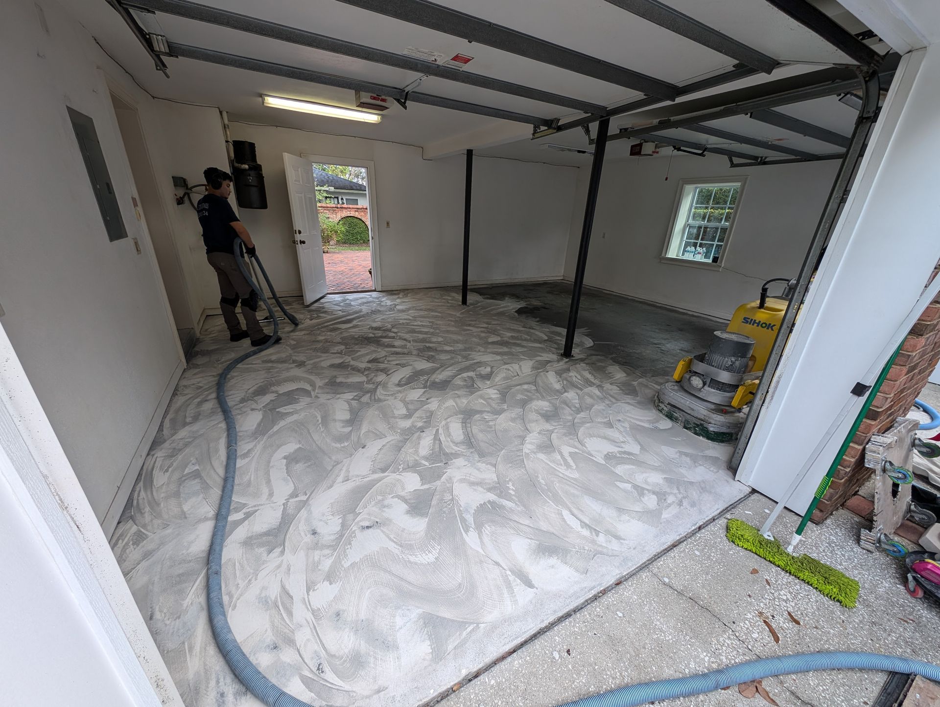 Home renovation room with freshly smoothed concrete floor and construction tools.