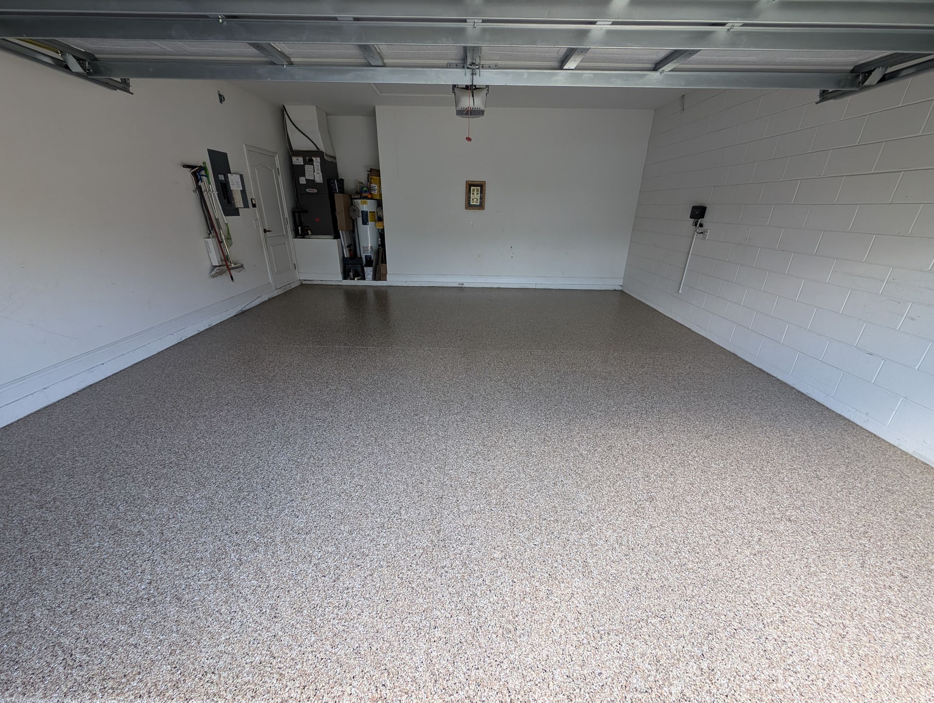 Empty garage with speckled epoxy floor and white walls
