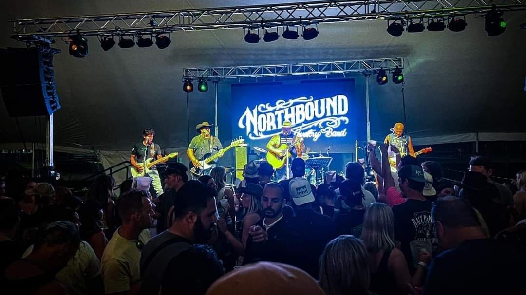Concert crowd watching a band perform on a lit stage with a blue “Northbound” backdrop.