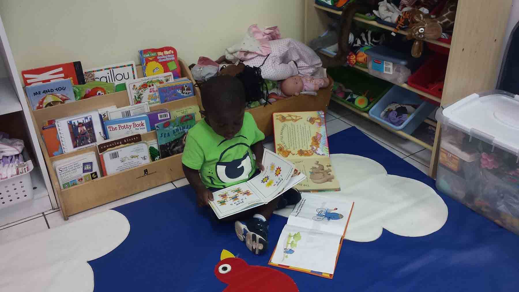 A Child is Sitting on the Floor Reading a Book
