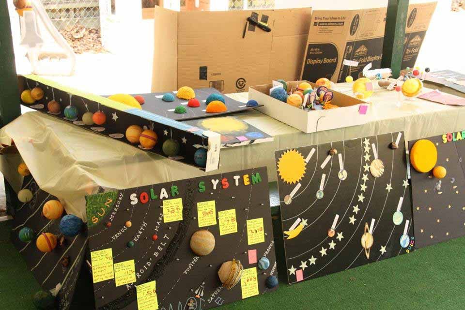 Table With a Solar System Made Out of Cardboard Boxes