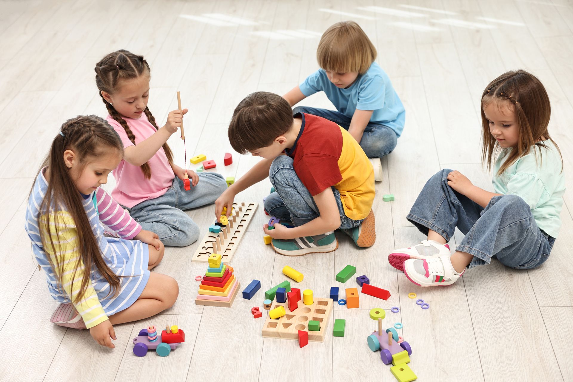 Group of Children Are Sitting on the Floor Playing With Toys