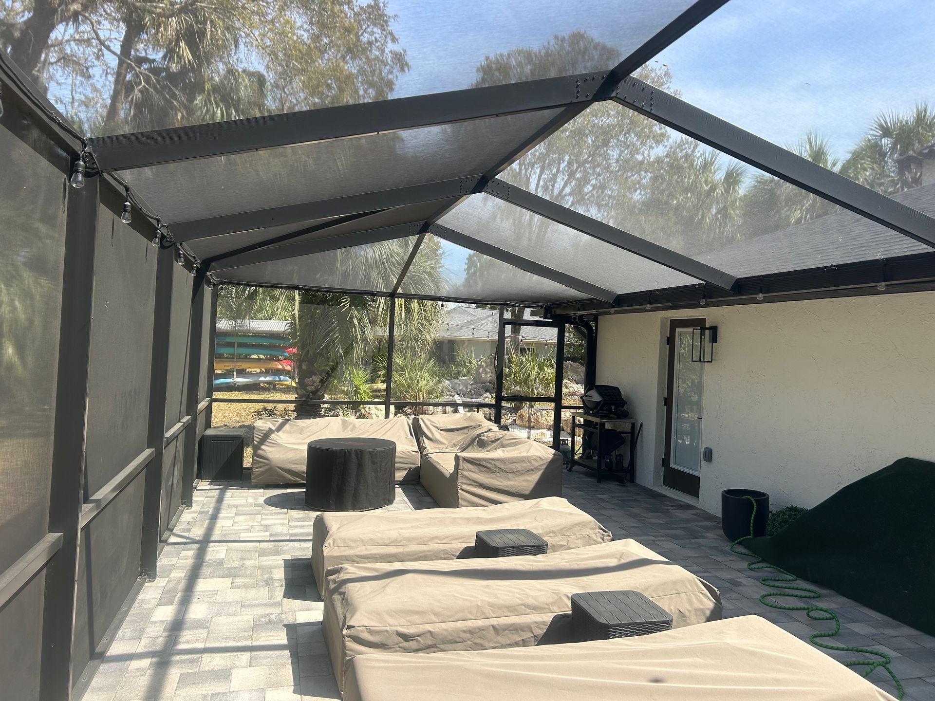 Patio with lounge chairs under a screened enclosure.