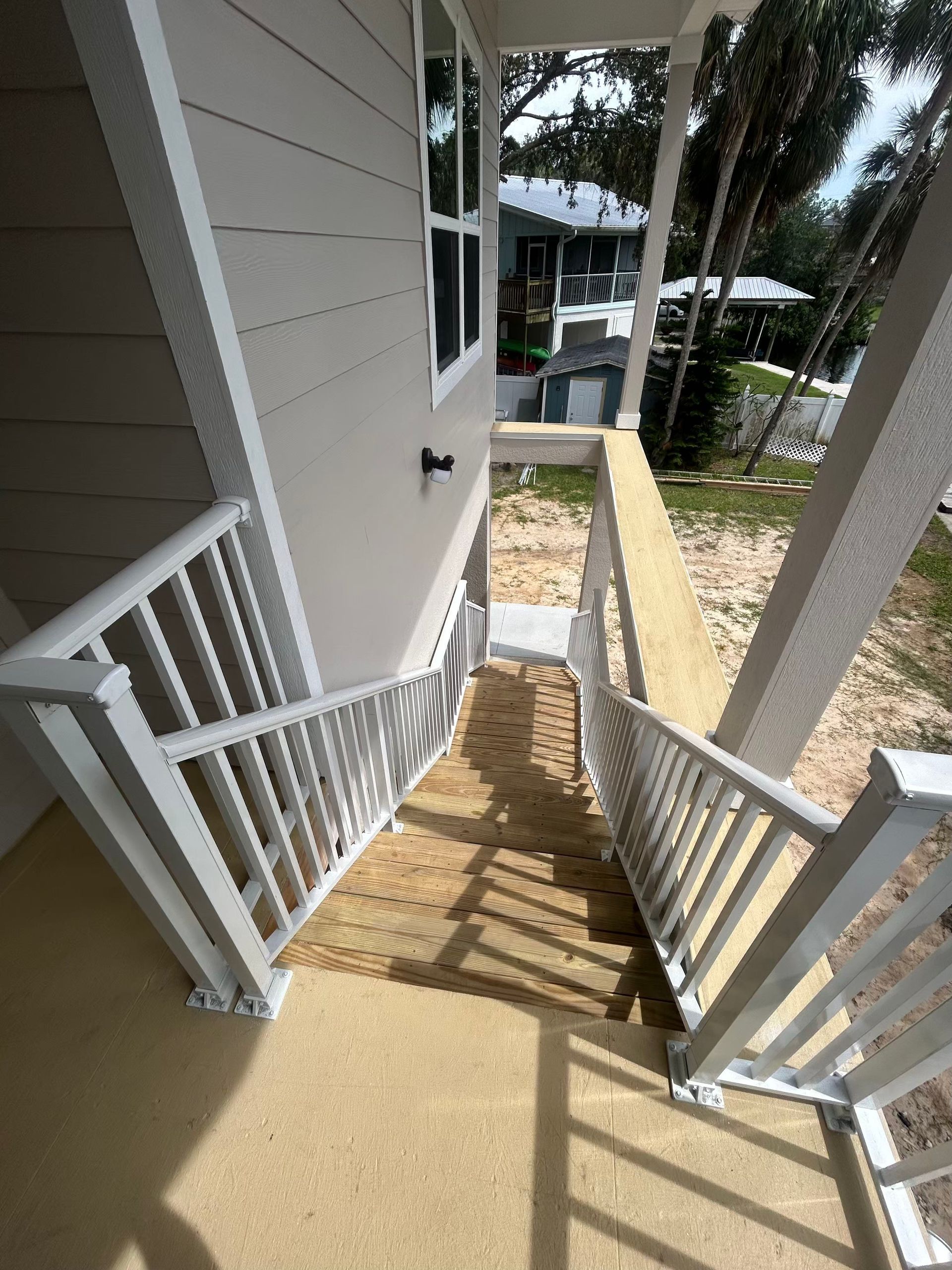 Screened porch with white roof attached to light-colored Florida home
