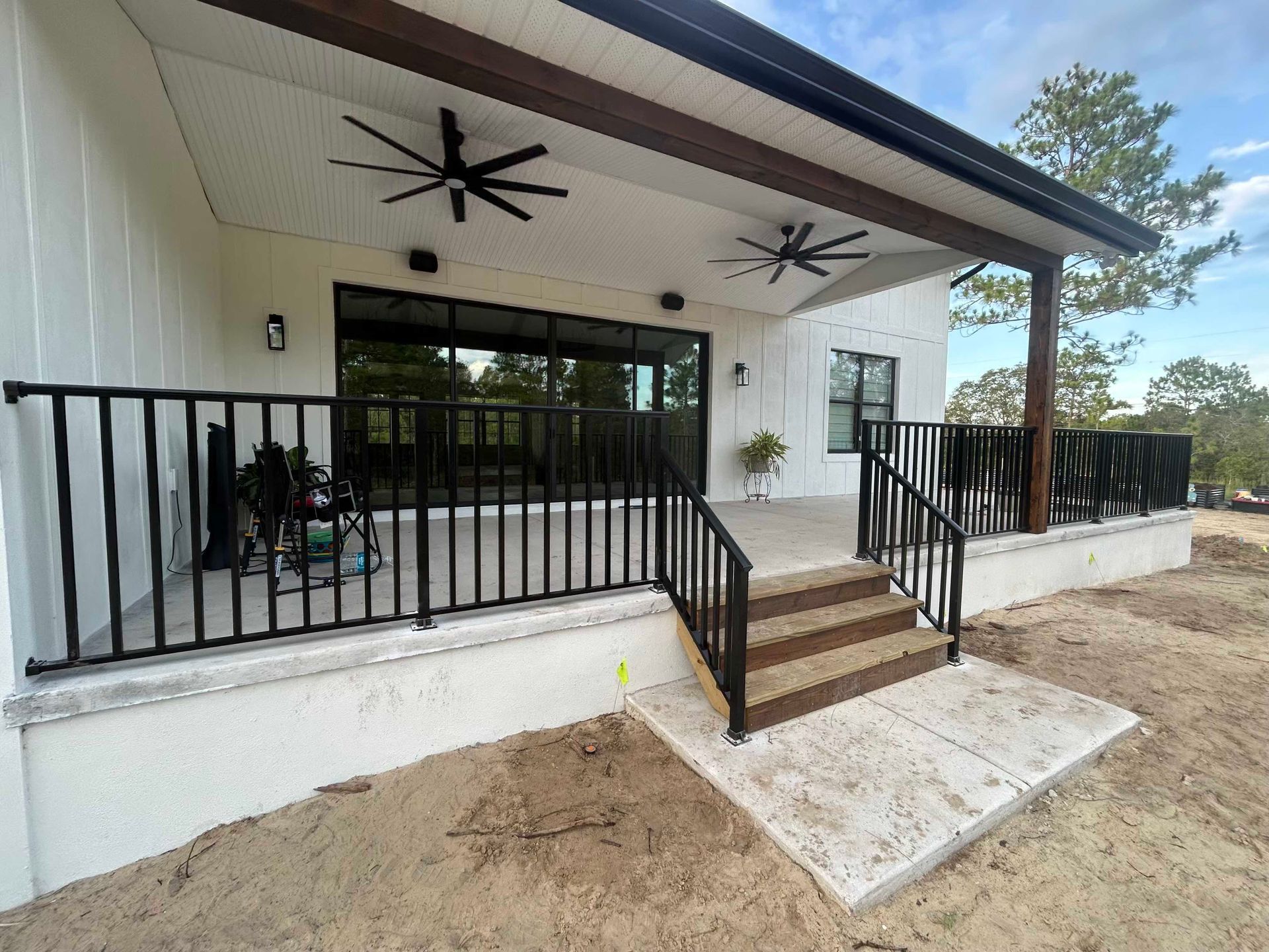 Interior screened porch with concrete floor, windows, and backyard view
