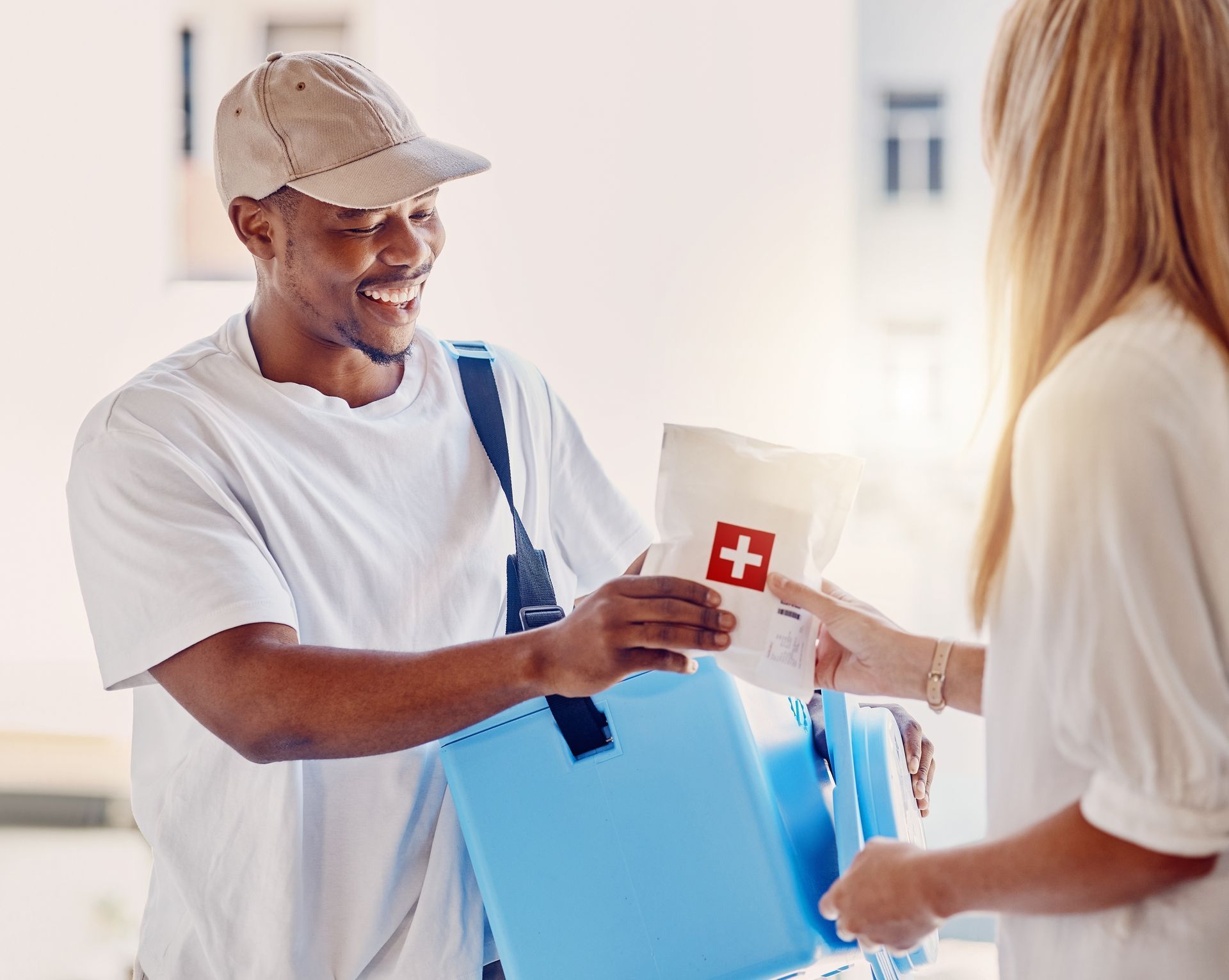 Man handing a donation box to a volunteer in a bright indoor setting