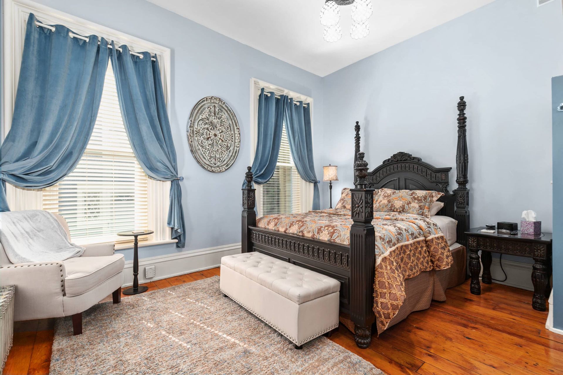 A bedroom with a bed , chair , table and window.