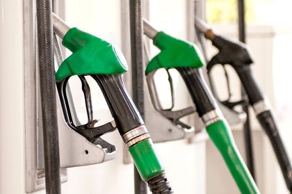 Ugelli della pompa di benzina, verdi, argentati e neri, montati in una stazione di servizio.