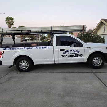 Garage door technician inspecting opener unit inside a Henderson NV residential garage