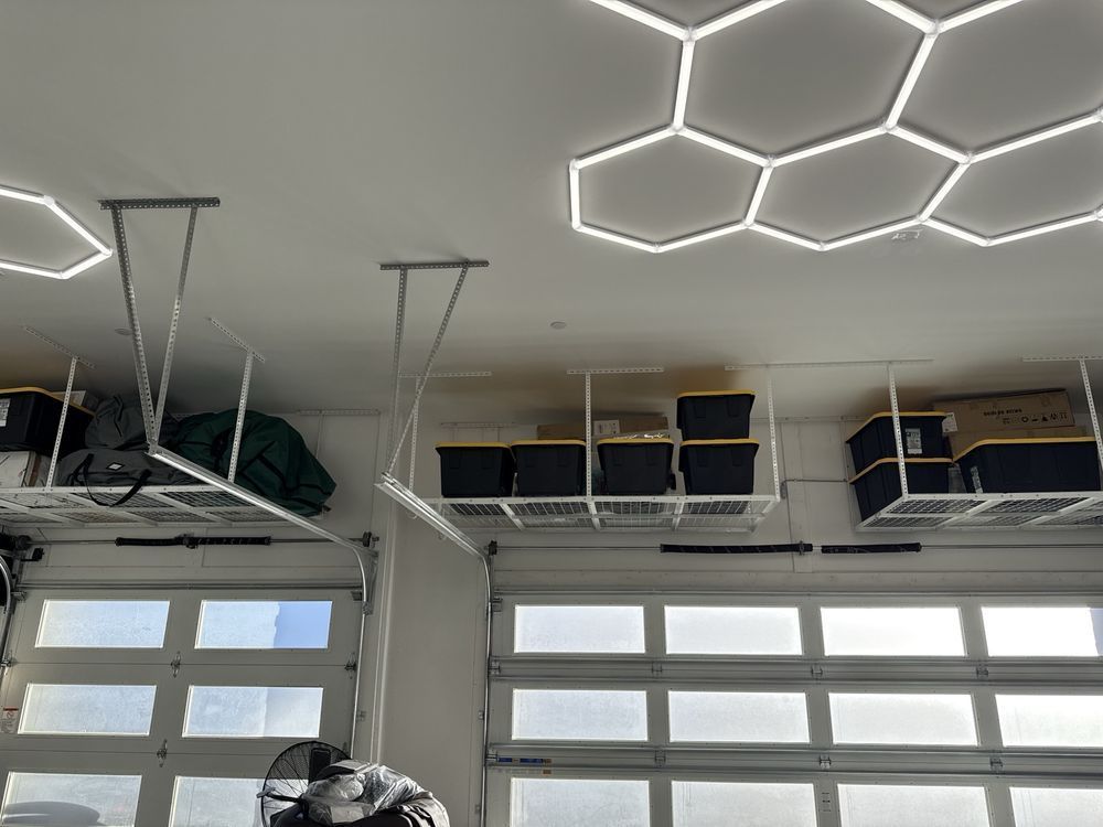 Empty white garage with two closed doors and ceiling-mounted garage door openers.