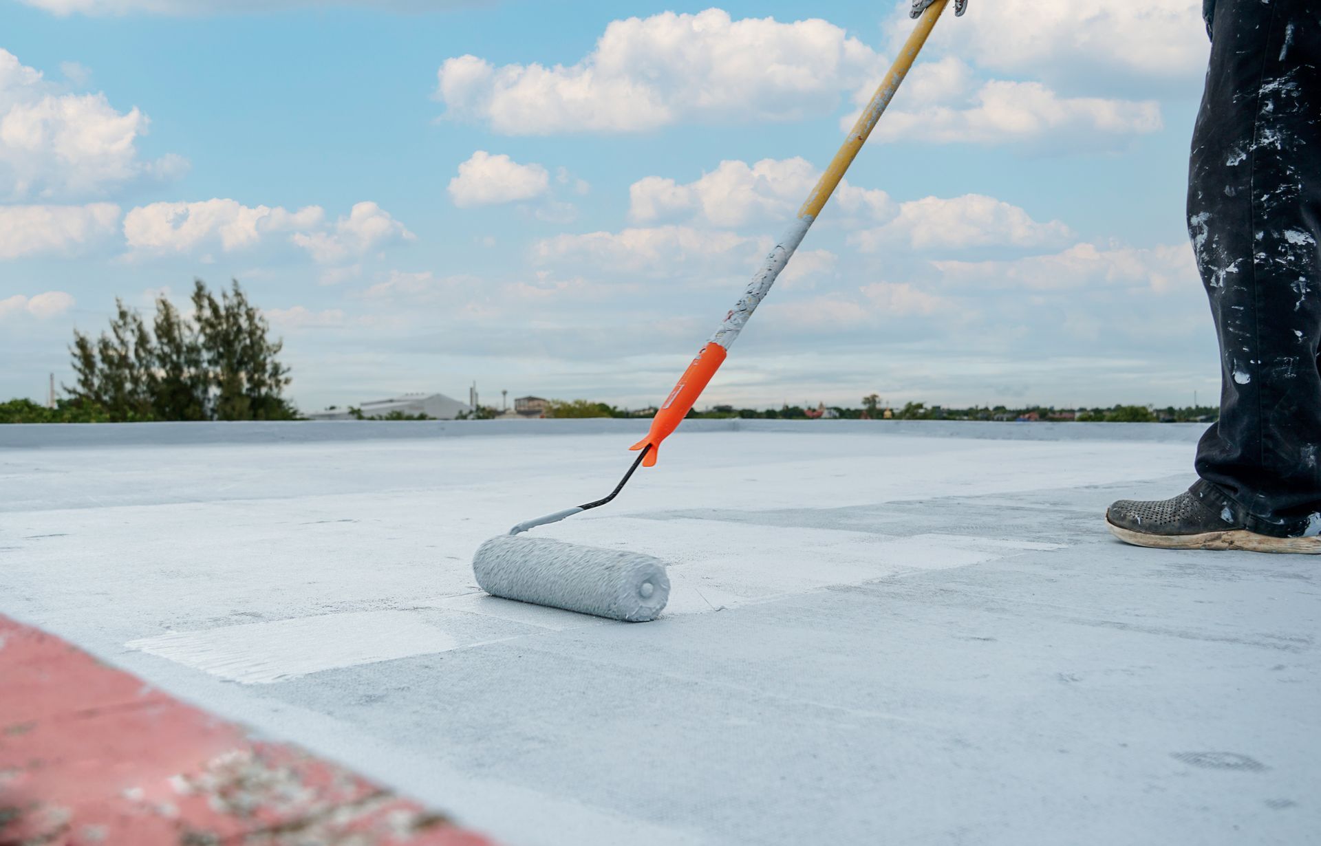 Applying waterproof coating on a flat roof.