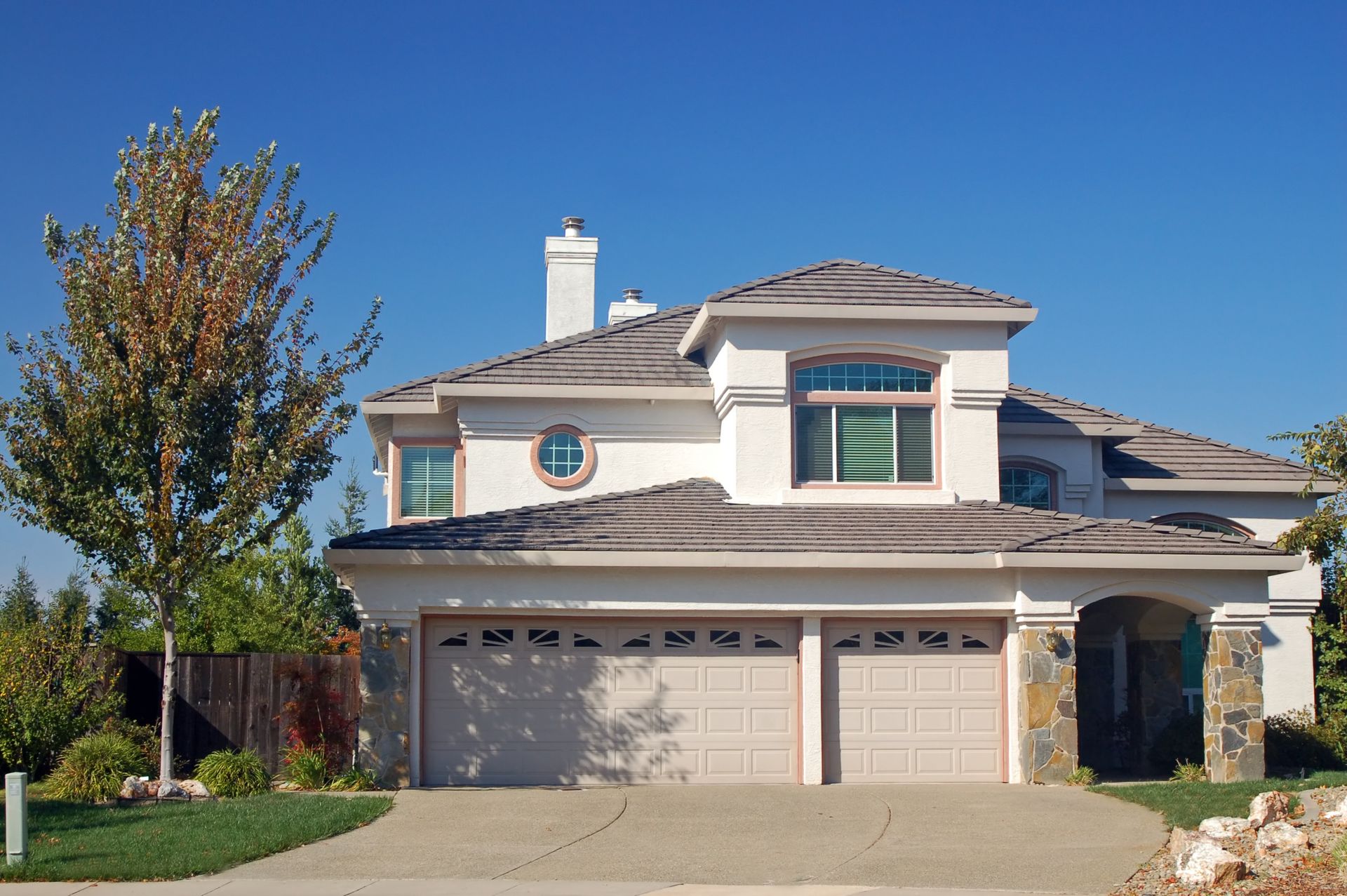 Professional roof installation on a large suburban house.