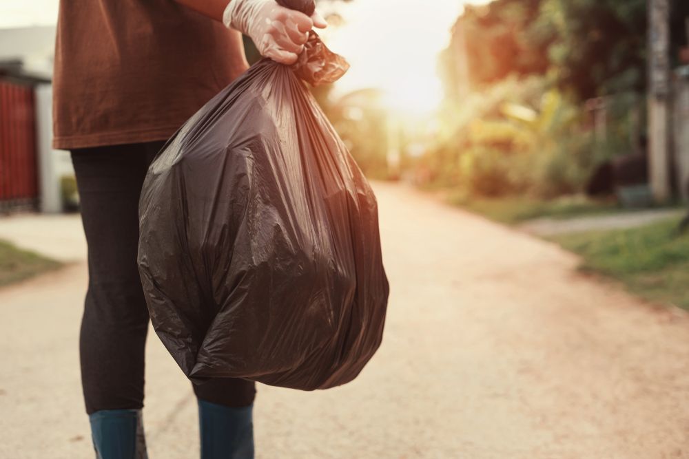Person Holding a Black Trash Bag — All Suburbs Garden Bags in Yorkeys Knob, QLD