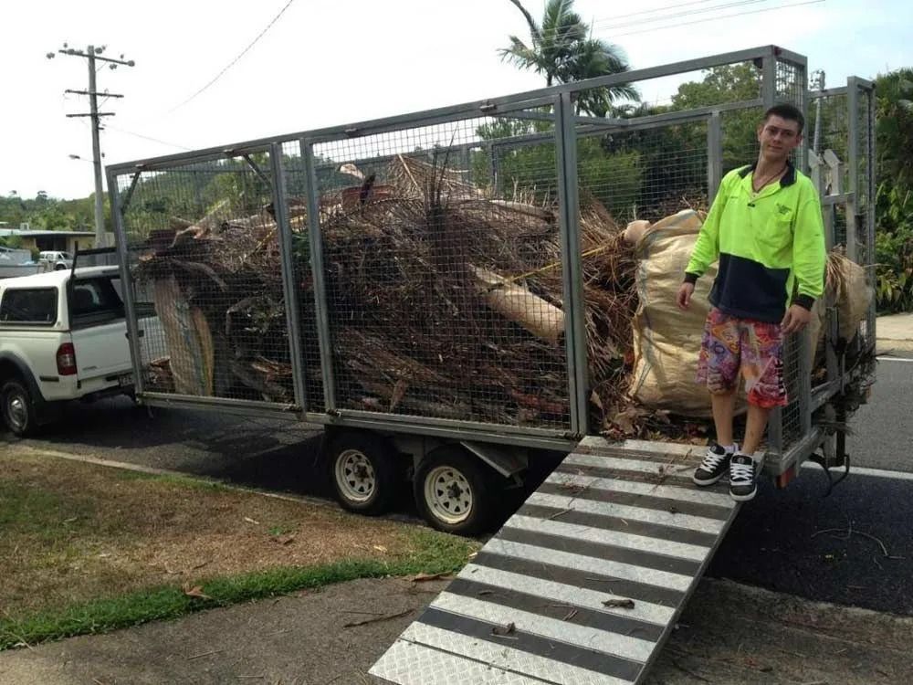 Man Standing Next to a Trailer Loaded With Brush and Bags; Ramp Extended — All Suburbs Garden Bags in Kuranda, QLD