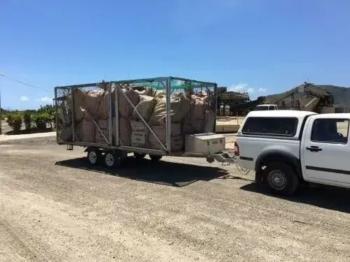 White Pickup Truck Towing a Trailer Loaded With Large Brown Bags — All Suburbs Garden Bags in Smithfield, QLD